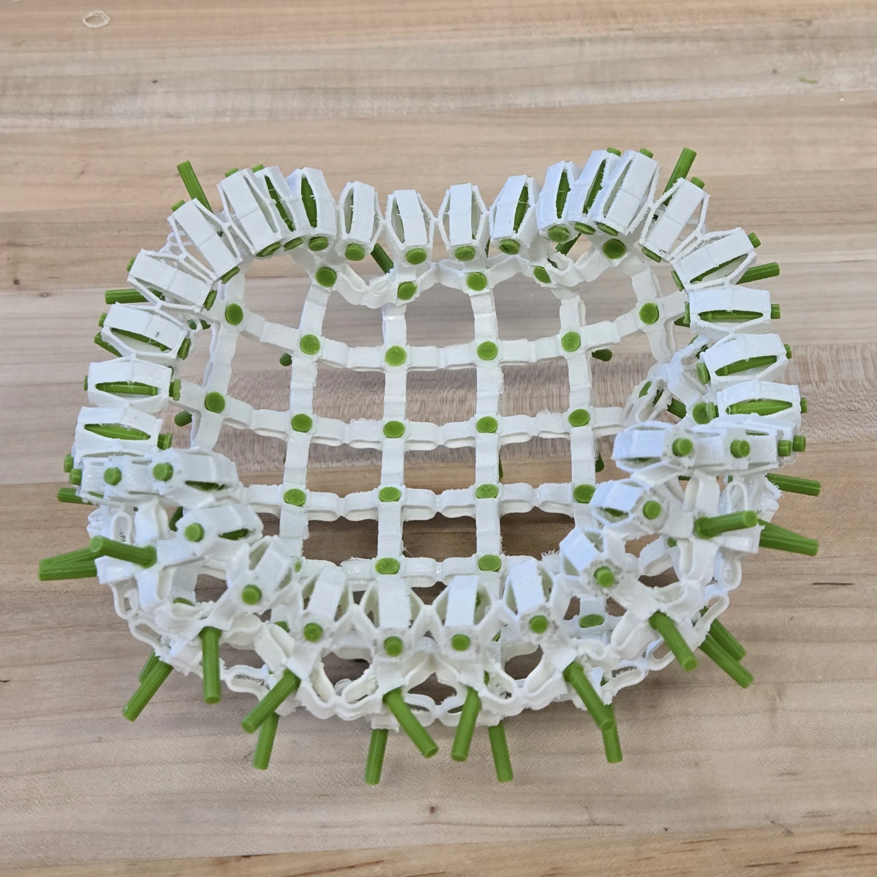 A reconfigured array of white linkages and green retaining components